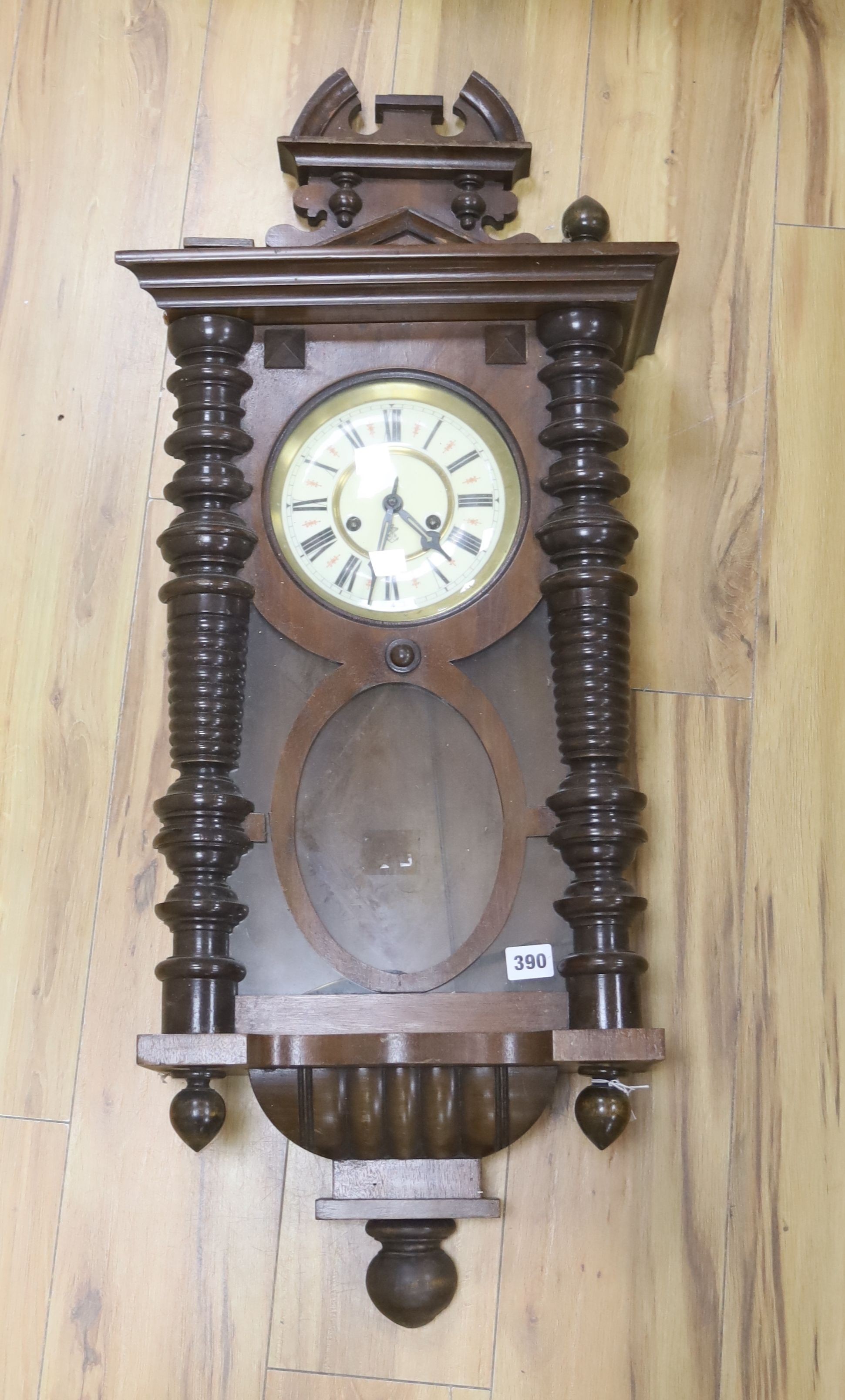 A 19th century Continental wall clock, in architectural walnut case, with key and pendulum, 95cm